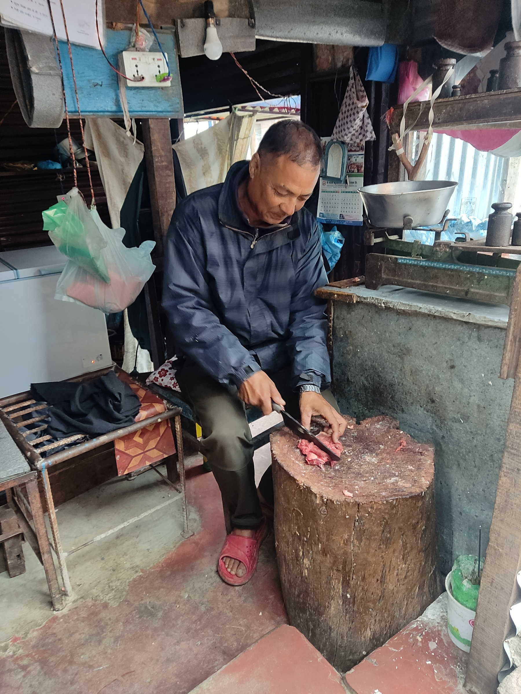 In the early morning light near Palpa Durbar, a town in Nepal's middle hills, Mangal Sahi skillfully butchers chicken and buffalo meat at his shop.


A lifelong resident of Palpa, he reflects on how much the city has changed; how land prices have soared, the familiar winter fog has vanished, and air pollution has worsened due to an increase in forest fires. He says he has also noticed a rise in health issues such as dengue and diarrhoea compared to the past.


Many residents of Palpa lack reliable mains water, though the municipality supplies water every 3-4 days, which residents must store and ration. This is potentially a health concern, as standing water can harbour diseas